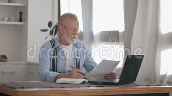 现代退休会计自由职业者在处理远程工作中的账户时在笔记本电脑上做日常工作视频的预览图