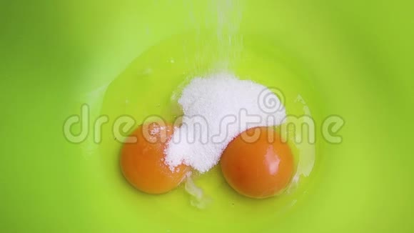 把糖果糖倒进蛋黄上的碗里把鸡蛋混合物中的糖放在一个塑料碗里m的过程视频的预览图
