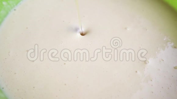 金黄色的液体带有气泡的葵花油和带有白色面团的碗表面的空气滴特写镜头制造过程视频的预览图