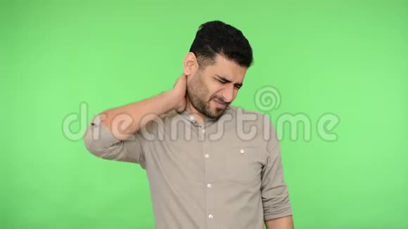 脖子疼精疲力竭的黑发男子按摩脖子和痛苦的鬼脸绿色背景色度键视频的预览图