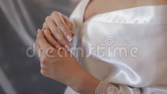 美丽可爱的新娘身穿睡衣抚摸着她的订婚戒指视频的预览图