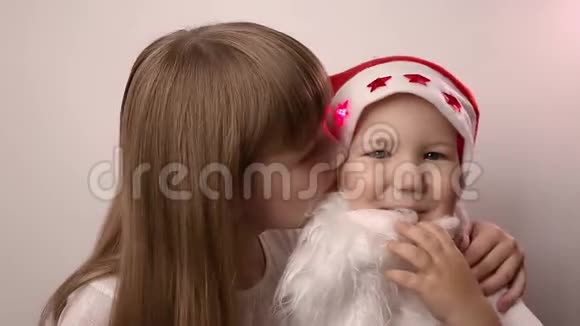 姐姐亲吻戴着圣诞老人帽子的假胡子的哥哥微笑笑视频的预览图