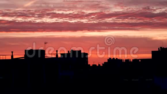 日落时橘色和粉色的天空覆盖着城市的屋顶摄像机自下而上的移动西班牙巴塞罗那视频的预览图