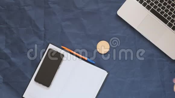 笔记本电脑笔记本电脑笔智能手机和咖啡蓝色背景复印空间视频的预览图