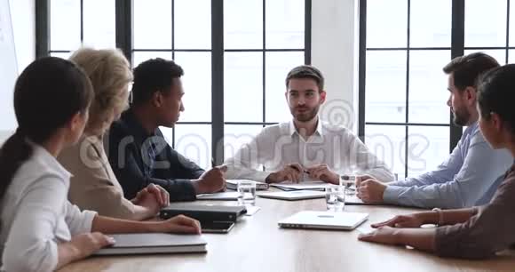 多种族的商人和坐在会议桌上的男老板交流视频的预览图