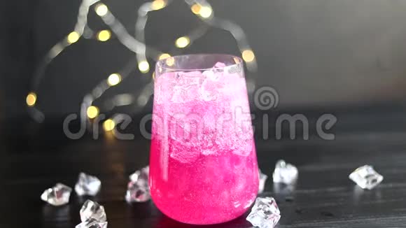 闪闪发亮的覆盆子饮料两个杯子里的香槟放在一张有冰的木桌上为了花和花环视频的预览图