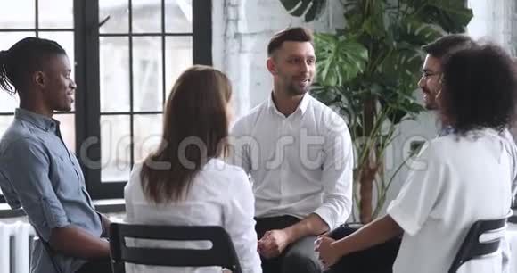 男教练心理学家在集体治疗期间围坐在一起视频的预览图