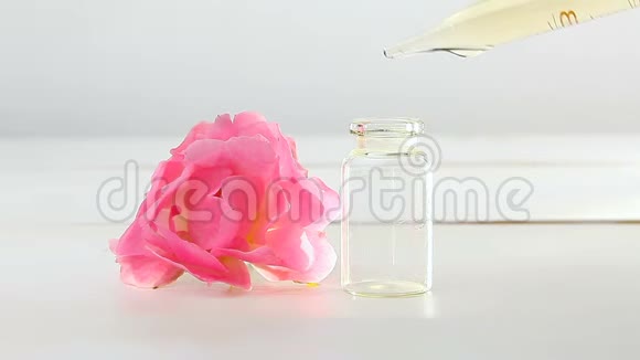 玫瑰花在白色背景上的精华在漂亮的玻璃瓶中视频的预览图