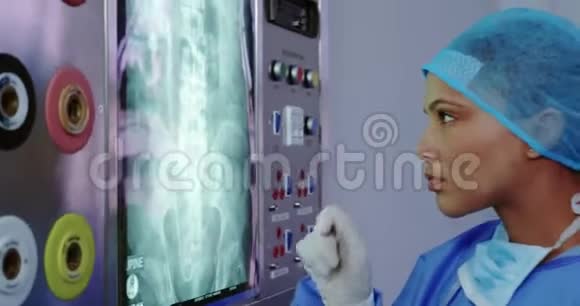 美籍非裔女医生在医院检查灯箱X光报告的特写视频的预览图