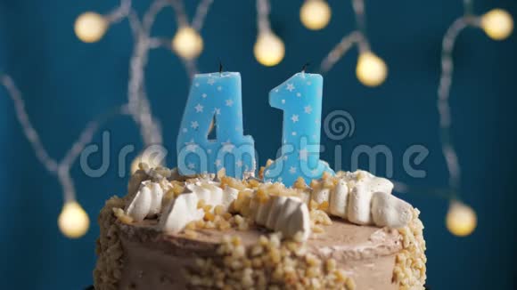 生日蛋糕蓝色背景上有41支蜡烛蜡烛吹灭了慢动作和特写视频的预览图
