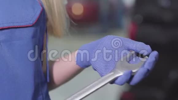 特写女性白种人手中的工作手套手持可调扳手无法辨认的金发女汽车修理工视频的预览图