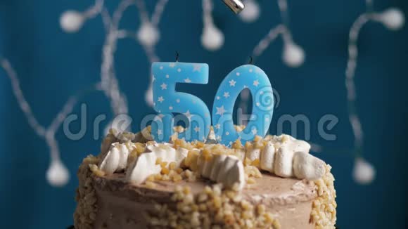 生日蛋糕蓝色背景上有50支蜡烛蜡烛吹灭了慢动作和特写视频的预览图