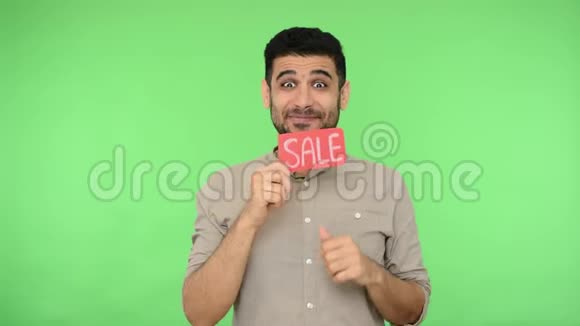 卖东西快乐的男人穿着衬衫的猪鬃手里拿着推销的字眼工作室镜头绿色背景色度键视频的预览图