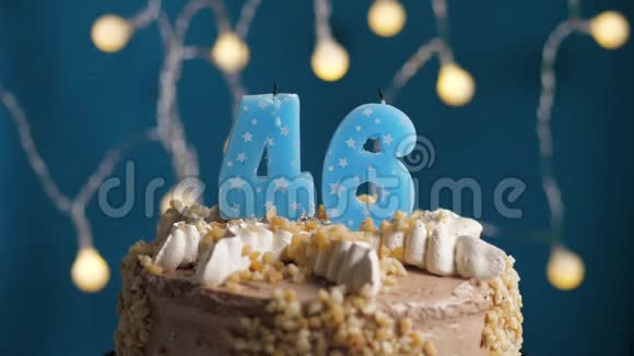 生日蛋糕蓝色背景上有46支蜡烛蜡烛吹灭了慢动作和特写视频的预览图