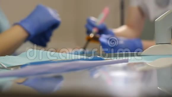 牙科模糊治疗通过工具射击在桌子上牙医和护士在工作特写病人视频的预览图