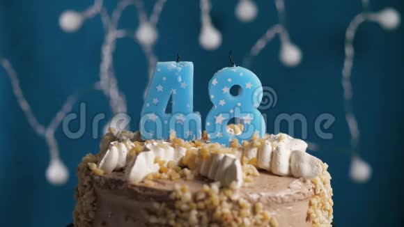 生日蛋糕蓝色背景上有48支蜡烛蜡烛吹灭了慢动作和特写视频的预览图