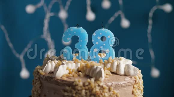 生日蛋糕蓝色背景上有38个数字蜡烛蜡烛吹灭了慢动作和特写视频的预览图