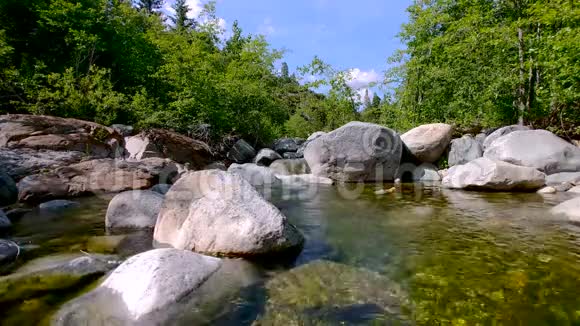 翡翠池小瀑布变成清澈的流水在碧蓝的天空下激起涟漪周围是绿松树视频的预览图