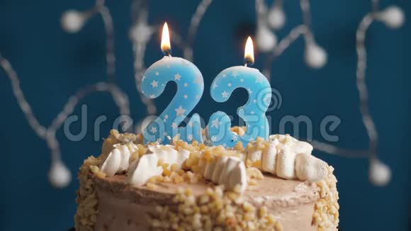 生日蛋糕与23号蜡烛和闪闪发光的蓝色背景慢速运动和特写镜头视频的预览图