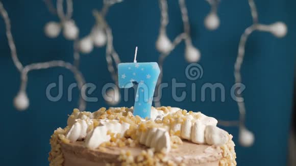 生日蛋糕蓝色背景上有7支蜡烛蜡烛吹灭了慢动作和特写视频的预览图