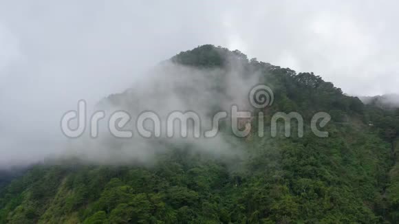 山峰覆盖着雨林和云层热带气候下的雨云视频的预览图