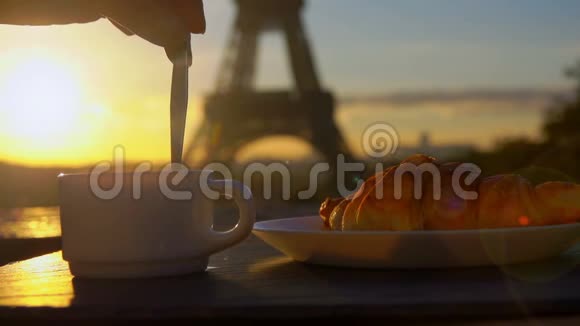 勺子在埃菲尔铁塔旁边的咖啡里搅拌糖视频的预览图