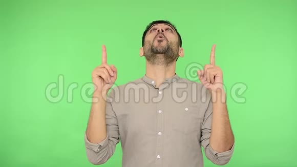 抬头看快乐的黑发男人穿着衬衫站起来赞许地点头室内摄影棚拍摄绿色背景视频的预览图