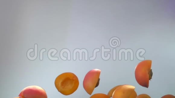 鲜辣的杏半部在白色的背景上飞起来视频的预览图