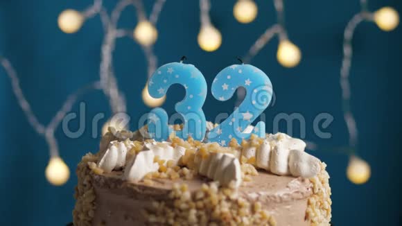 生日蛋糕32号蜡烛在蓝色的背景上蜡烛吹灭了慢动作和特写视频的预览图