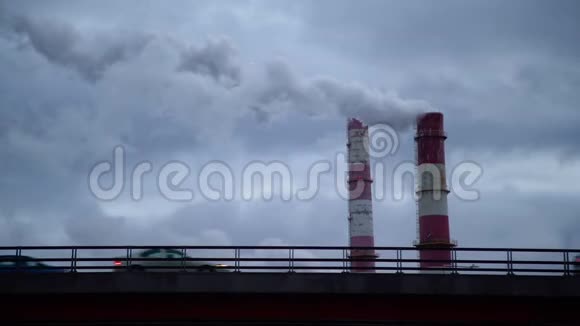 从工厂烟囱出来的深色有毒烟云在汽车交通上方的时间推移空气污染和全球变暖视频的预览图
