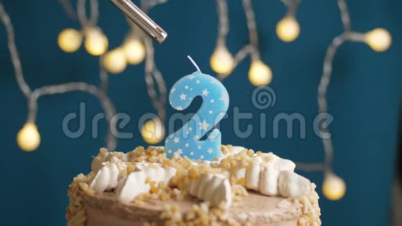 蓝背上有两支蜡烛的生日蛋糕蜡烛吹灭了慢镜头和特写镜头视频的预览图