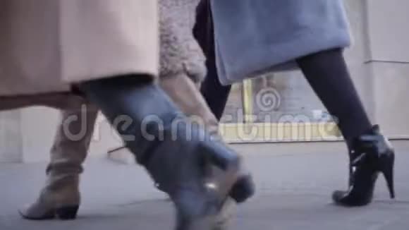 穿着高跟鞋和外套的女腿在城市的街道上行走相机遵循时尚的步骤视频的预览图