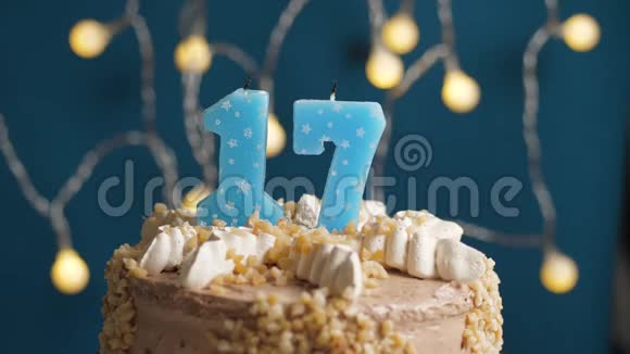 生日蛋糕蓝色背景上有17根蜡烛蜡烛吹灭了慢动作和特写视频的预览图