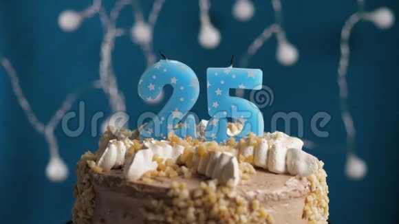 生日蛋糕有25个数字蜡烛在蓝色的背景上蜡烛吹灭了慢动作和特写视频的预览图
