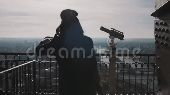 年轻美丽的女子站在埃菲尔铁塔上巴黎全景走到边缘在镜头下缓慢地摆姿势视频的预览图
