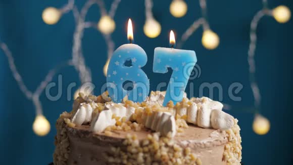 生日蛋糕蓝色背景上有67根蜡烛蜡烛吹灭了慢动作和特写视频的预览图