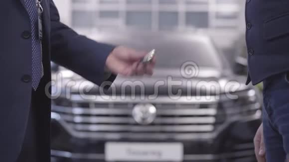 特写男性白种人的手把车钥匙给顾客握手汽车经销商将固定汽车归还客户视频的预览图