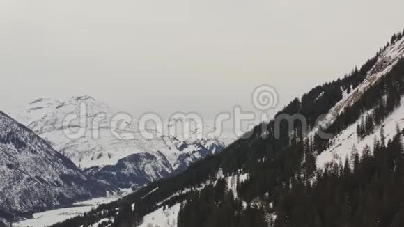 在多云的一天里山上的空中俯瞰着阿尔卑斯山的积雪和树木飞来飞去的莫因坦在看视频的预览图