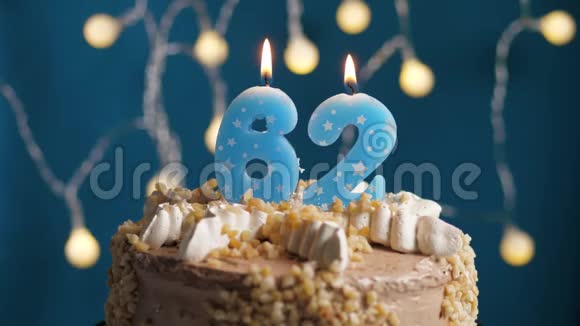 生日蛋糕62号蜡烛在蓝色的背景上蜡烛吹灭了慢动作和特写视频的预览图