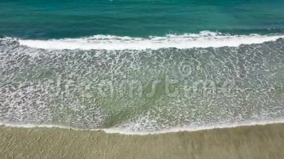 海滩和波浪从顶部看从顶部看绿松石水背景夏天从空气中渗出无人驾驶飞机的俯视图视频的预览图