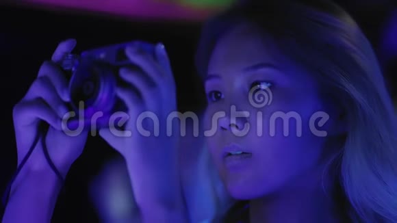 青年亚洲女孩在俱乐部或购物中心的聚会上拍摄照片或视频视频的预览图