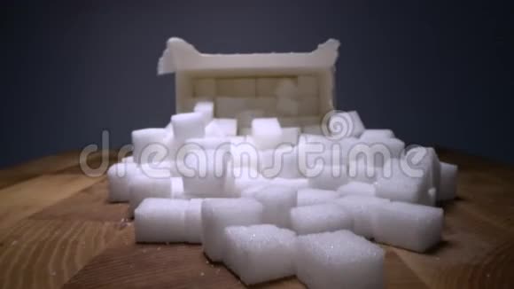 在木桌上的纸盒子里一个巨大的从糖块中滑过不健康食品甜味剂甜水晶视频的预览图