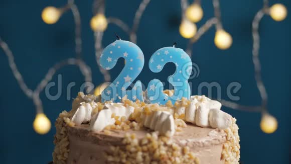 生日蛋糕蓝色背景上有23支蜡烛蜡烛吹灭了慢动作和特写视频的预览图
