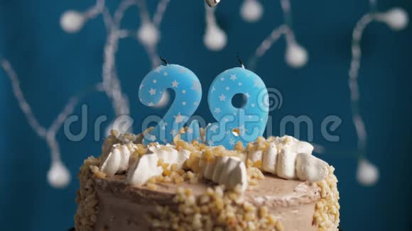 生日蛋糕蓝色背景上有29支蜡烛蜡烛吹灭了慢动作和特写视频的预览图