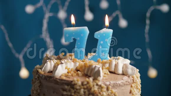 生日蛋糕71号蜡烛在蓝色的背景上蜡烛吹灭了慢动作和特写视频的预览图