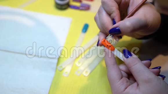 用刷子把女人的油漆贴在指甲上在胶钉上画画指甲艺术视频的预览图