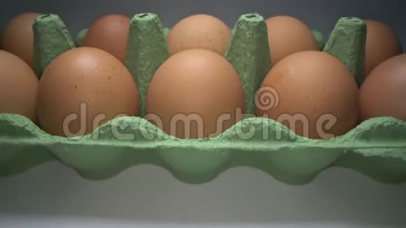 在白色背景上的纸板箱里滑动着两排棕色的鸡蛋出售篮子中的鸡蛋视频的预览图