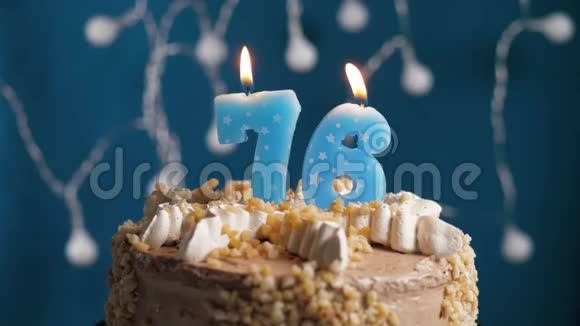 生日蛋糕76号蜡烛在蓝色的背景上蜡烛吹灭了慢动作和特写视频的预览图