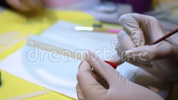 用刷子把女人的油漆贴在指甲上在胶钉上画画指甲艺术视频的预览图