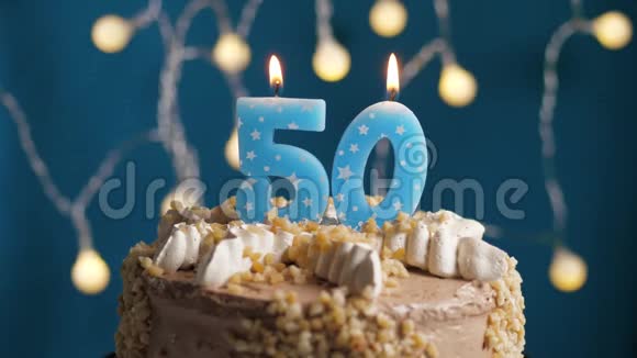 生日蛋糕蓝色背景上有50支蜡烛蜡烛吹灭了慢动作和特写视频的预览图